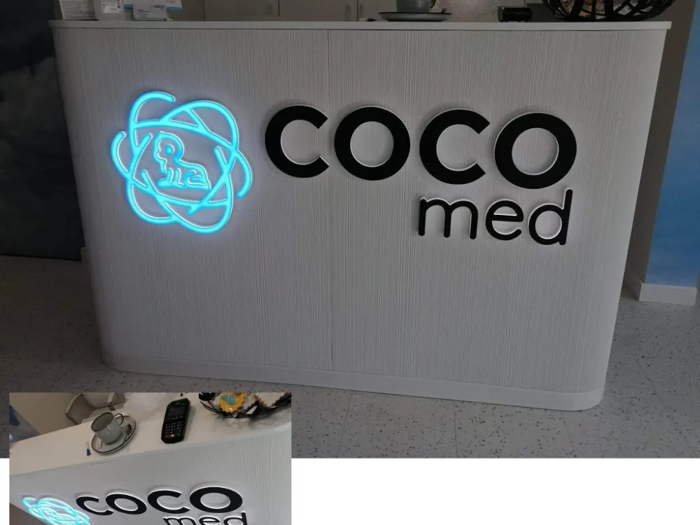Podświetlane logo firmy zamontowane na ladzie recepcyjnej