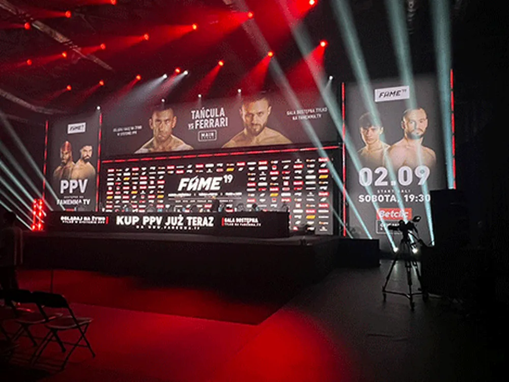 Scena eventowa z ekranami wyświetlającymi materiał reklamowy