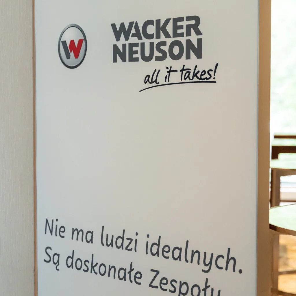 Grafika ścienna z hasłem w biurze Wacker Neuson