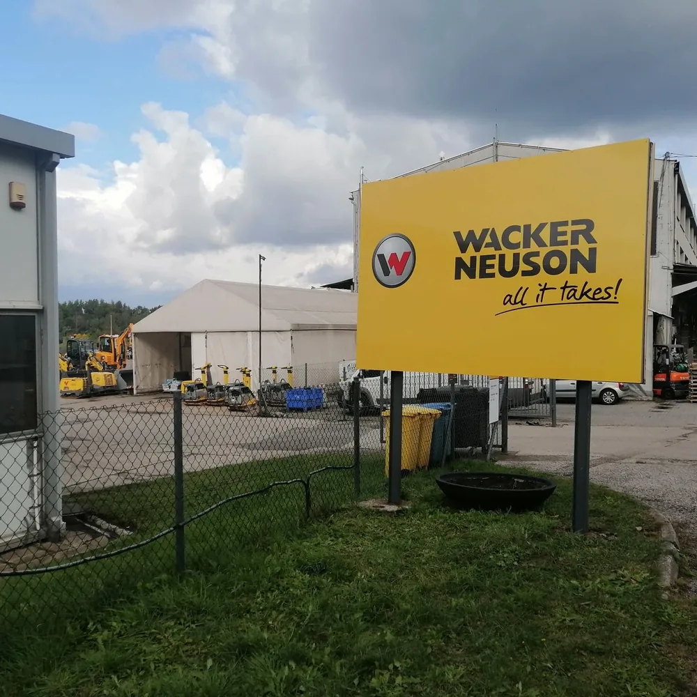 Tablica Wacker Neuson na słupach przed oddziałem