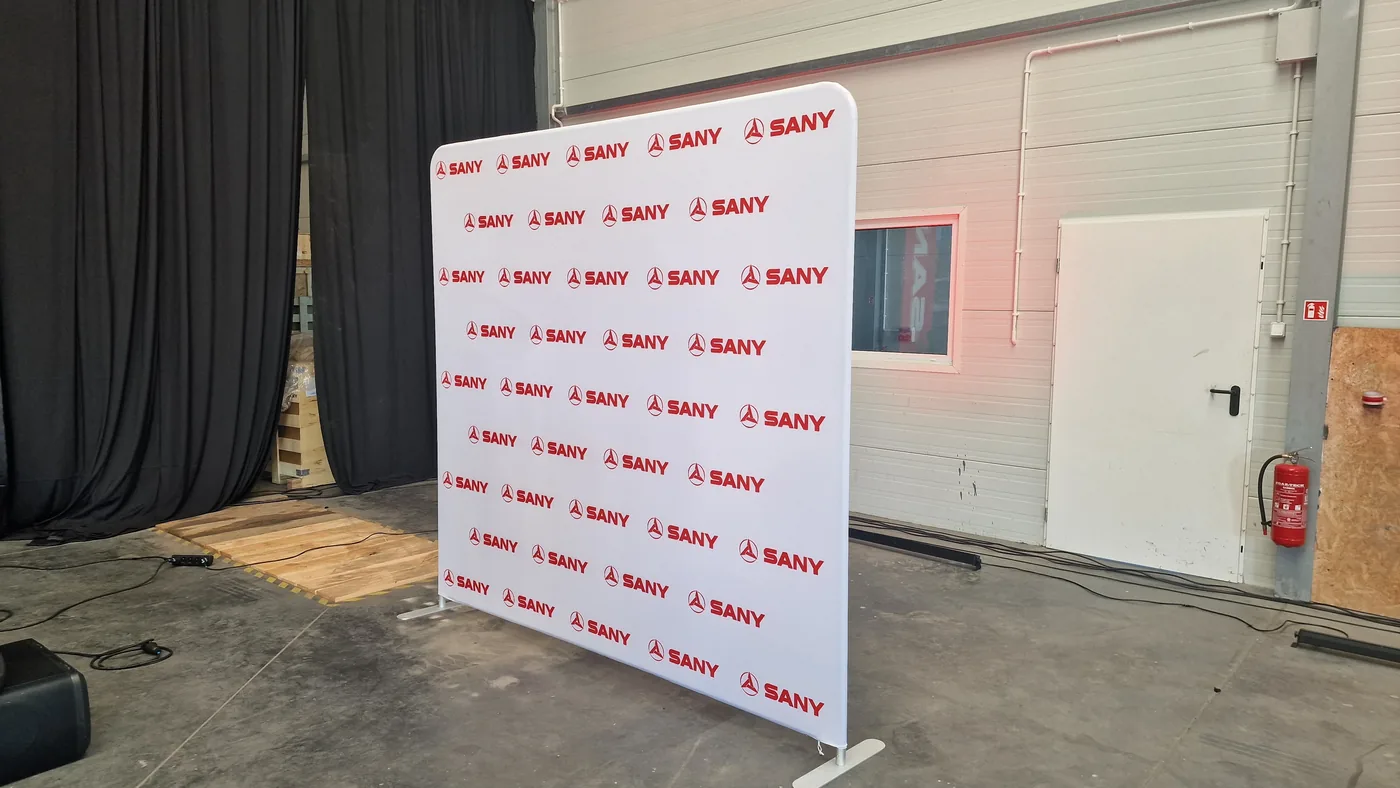 Ścianka reklamowa SANY z logotypami, ustawiona w hali eventowej