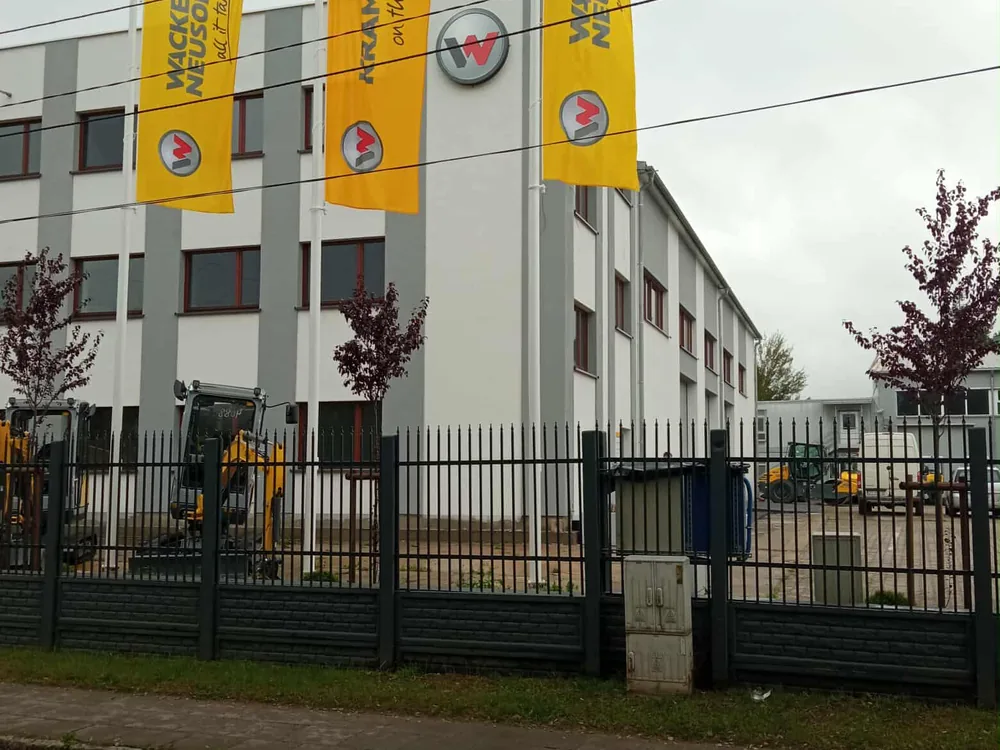 Flagi reklamowe i szyld przed halą Wacker Neuson
